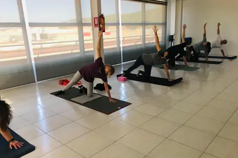 Una classe de ioga en grup, amb les finestres al fons