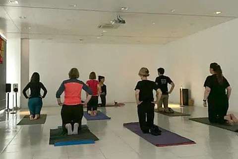 Un grup de persones practicant ioga a la sala d’una empresa