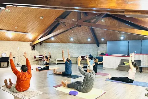Un grup practicant a la sala, amb els braços cap amunt