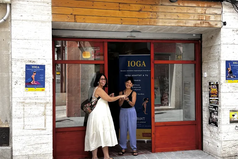 La Lidia Amaya donant la mà a la propietària del local, a la porta de la sala