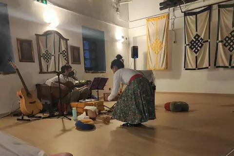 La Lidia preparant l’altar de la cerimònia de cacau, amb un músic tocant la guitarra