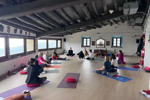El grup assegut en cercle a la sala, en meditació