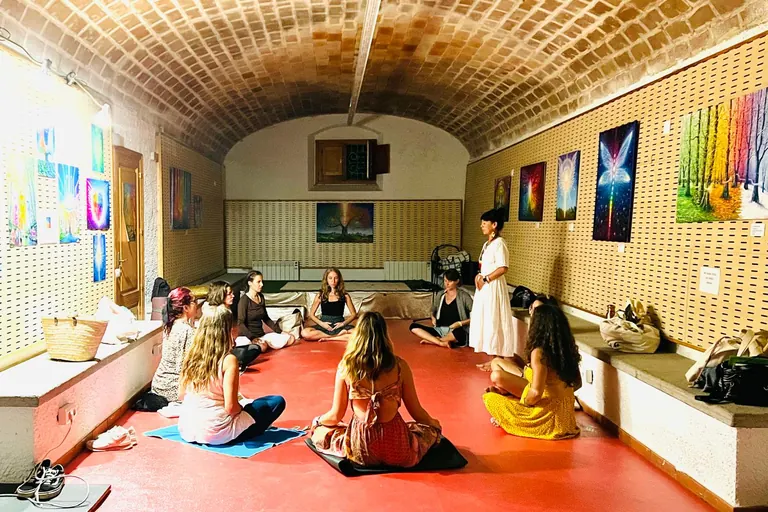 Un grup de dones assegudes en cercle durant un taller de sanació del sagrat femení